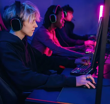 Equipa de jogadores competitivos de PC, equipados com auscultadores RGB para jogos e a jogar em conjunto num centro profissional de eSports com computadores de alto desempenho.